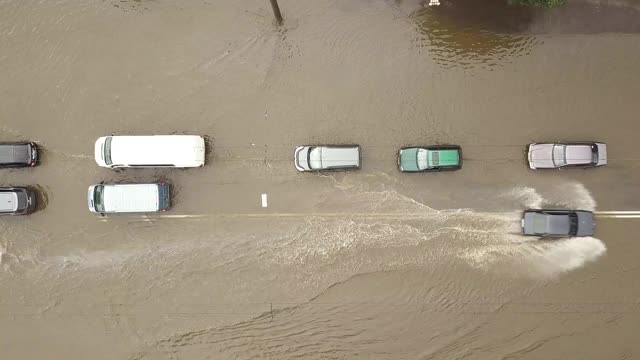 交通车辆在被雨水淹没的道路上行驶的鸟瞰图。视频素材