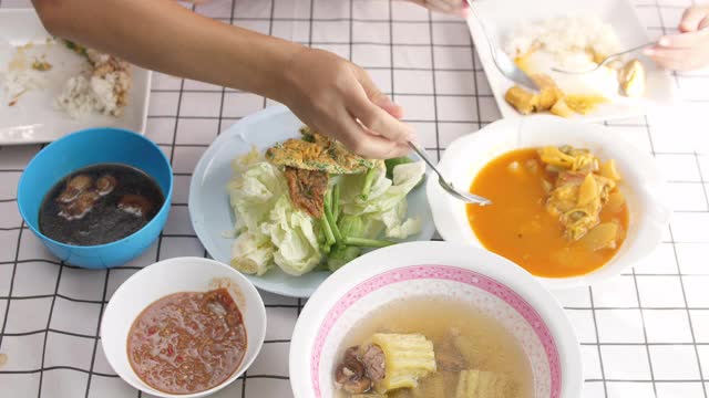 幸福的家庭时间和关系，亚洲家庭在家里一起吃午饭，在家里分享食物视频素材