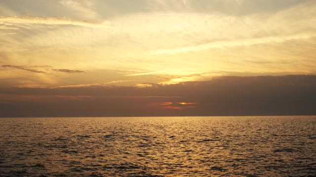 美丽的日落在海岸，海面水波浪移动，鸟瞰视频素材