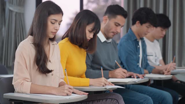 大学生在教室里学习和写笔记视频素材