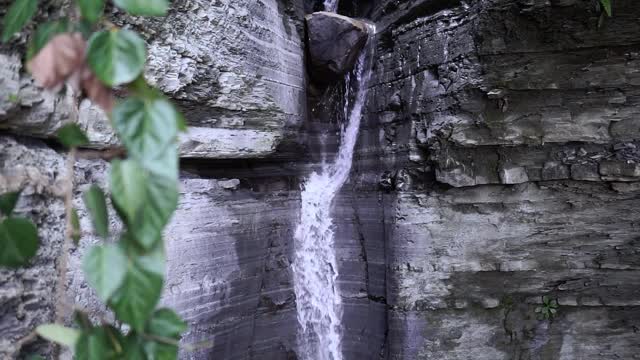 瀑布在森林景观中顺流而下的石头。选择性聚焦，模糊水。视频素材