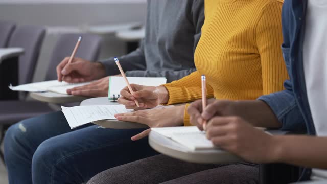 近距离观察大学生在教室里学习和写笔记视频素材