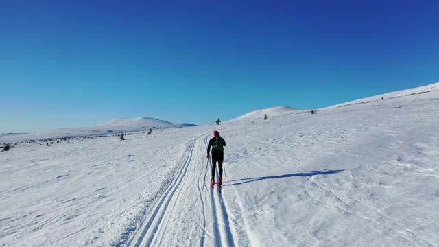 从后面用无人机拍摄的越野滑雪者视频素材