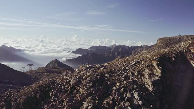 鸟瞰图的岩石山悬崖。美丽的风景在背景，云覆盖较低的山峰在一个阳光明媚的夏日视频素材