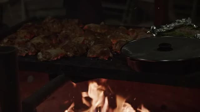 用铸铁在明火烤架上烹饪鸡肉和蔬菜视频素材