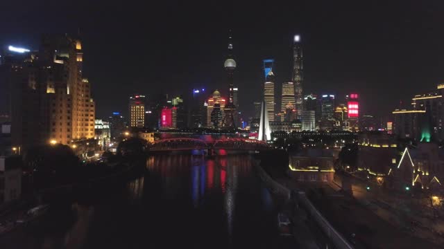 夜晚照亮上海天际线。陆家嘴区，黄浦江和苏州河。中国鸟瞰图。无人机是向前和向上飞行。远景视频素材