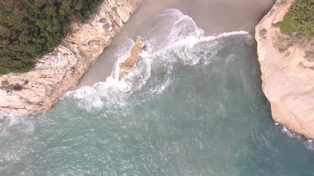 鸟瞰海浪到达海滩和岩石视频素材