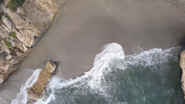 鸟瞰海浪到达海滩和岩石视频素材