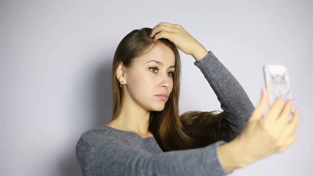 漂亮女孩用她的智能手机自拍视频素材