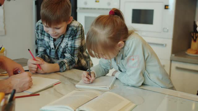 孩子们和弟弟妹妹一起做作业，然后在家里击掌视频素材