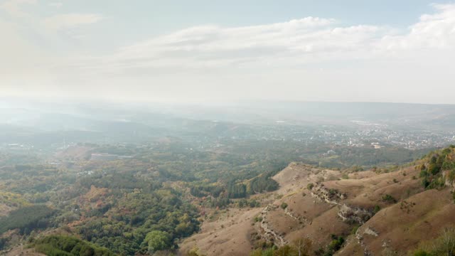 骑着自行车旅行的人站在山径边上的全景景观。登山和极限自行车耐力旅行。无人机俯瞰山谷中的美丽城市。视频素材