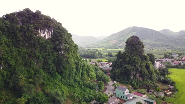 鸟瞰风景如画的乡村村庄，悬崖上覆盖着郁郁葱葱的植物。视频素材