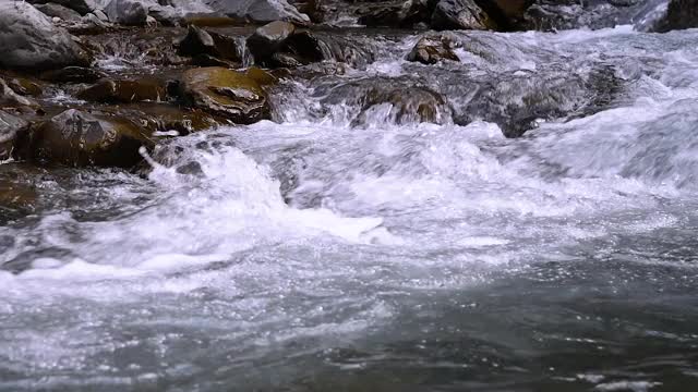 奔流着巨石和石滩的野生山河。纯净的山水从岩石上流过视频素材