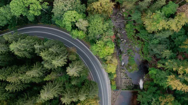 鸟瞰图的汽车行驶在乡村道路，山脉森林。视频素材