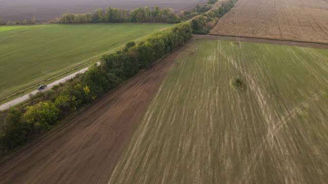 无人机拍摄的道路，移动的汽车和绿地。高速公路，田野和树木。视频素材