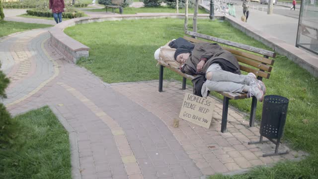 女陌生人给穷女人捐钱，睡在长凳上，慈善视频素材