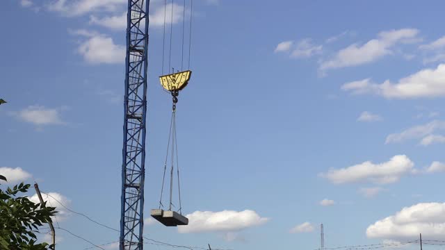 一个巨大的建筑起重机顶着天空承载着混凝土。建筑材料。视频素材