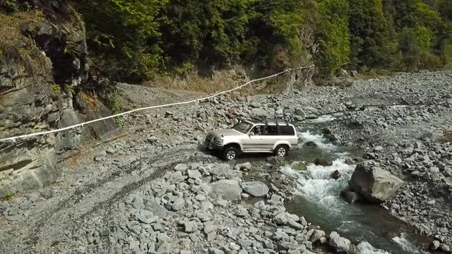 越野车辆穿越野生山河。suv汽车鸟瞰图视频素材