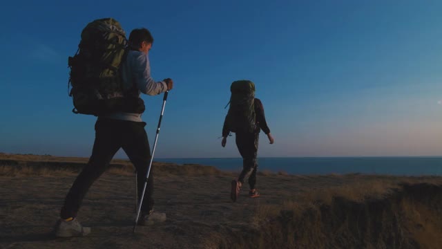 一男一女背着背包在海边旅行。慢动作视频素材