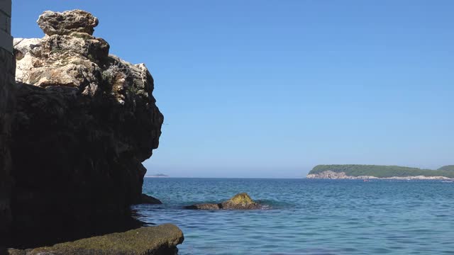 在杜布罗夫尼克附近，克罗地亚亚得里亚海的平静波涛上的海岸岩石视频素材