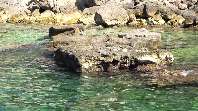 像禅宗波浪图案的亚得里亚海海浪轻轻抚摸着海岸的岩石视频素材