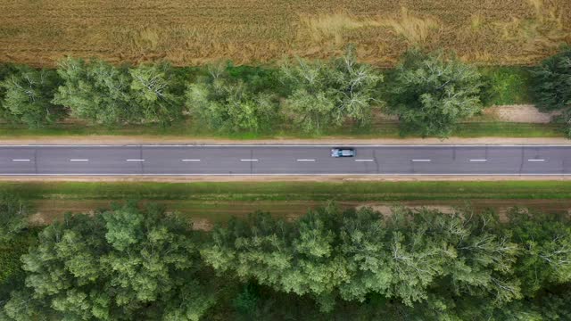 城际公路公路通过农田与驾驶汽车鸟瞰图视频素材