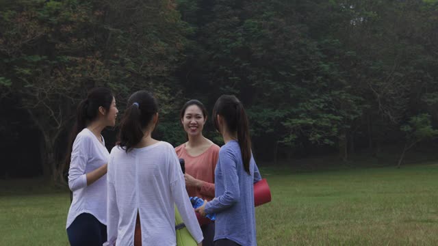 亚洲中国年轻女性在公园晨练后交谈视频素材