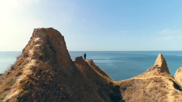 游客站在以海景为背景的山脉上视频素材