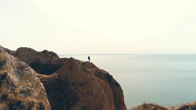 游客站在山崖上，背景是海景视频素材