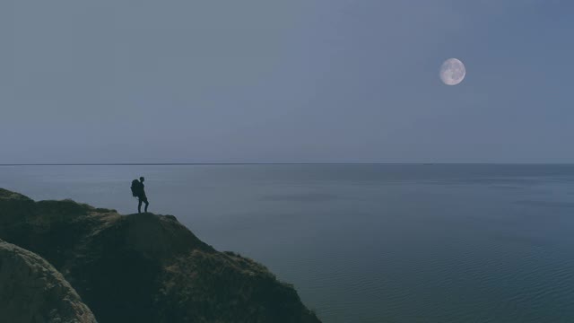 旅行者站在山崖上，以夜景为背景视频素材