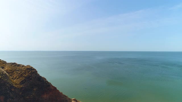 那个背着背包的人站在山边美丽的海景上视频素材