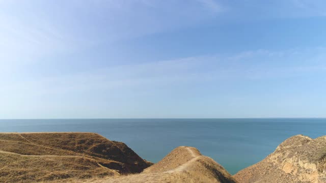 旅行者站在山脉上欣赏美丽的海景视频素材