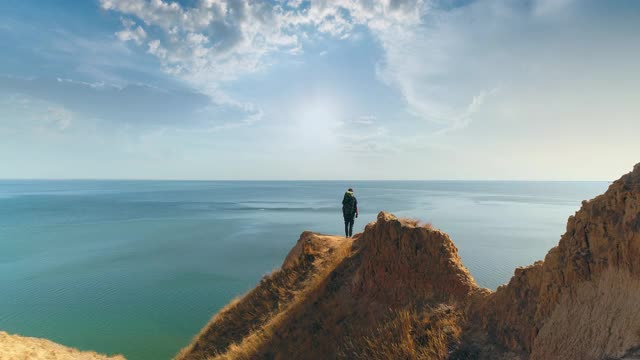 旅行者站在以海景为背景的山脉上视频素材