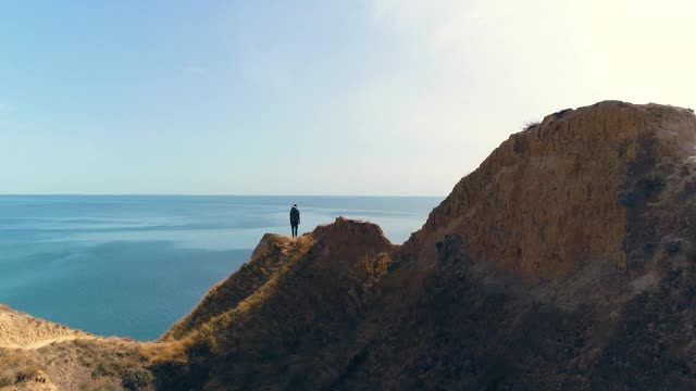 游客站在以海景为背景的山脉上视频素材