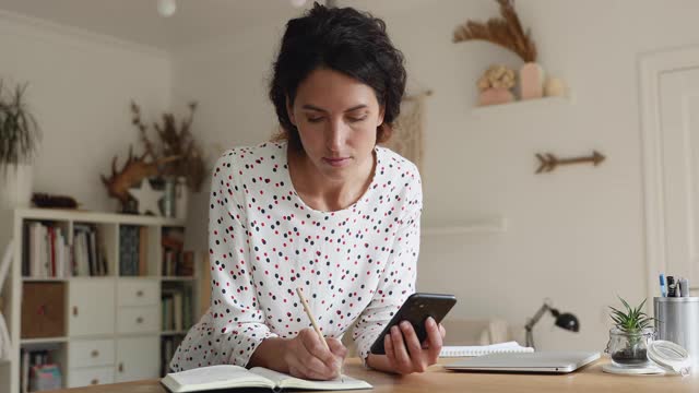 女人在互联网上搜索信息，把它写在组织者视频素材