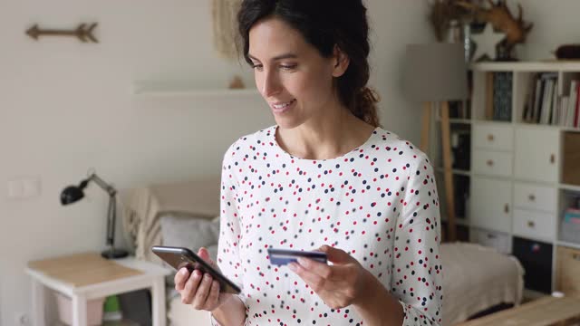 手持智能手机和信用卡的女性进行电子支付视频素材