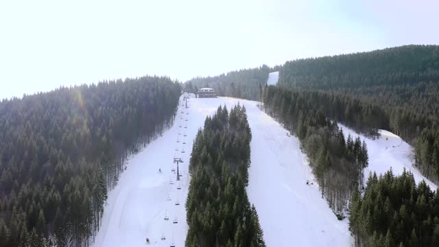 在冬季滑雪胜地，无人机飞过一群滑雪的人。贡多拉滑雪板雪景美丽洁白。视频素材