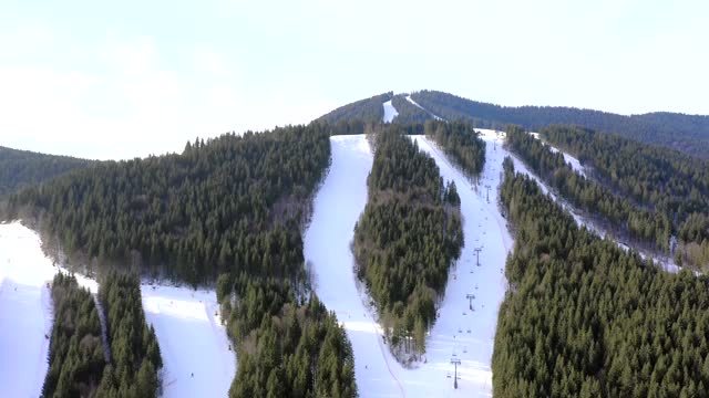 在冬季滑雪胜地，无人机飞过一群滑雪的人。贡多拉滑雪板雪景美丽洁白。视频素材