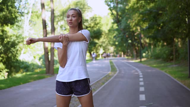 女人跑步伸展手臂之前锻炼夏季公园早上视频素材