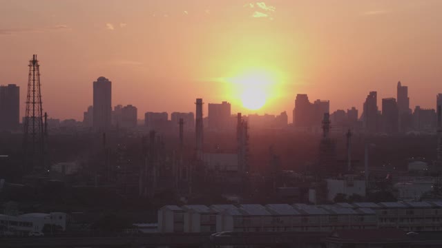 炼油厂日落与大城市的背景视频素材