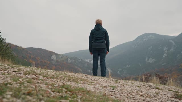 老妇人站在山顶上视频素材