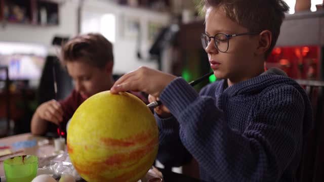 小男孩在家里制作太阳系模型视频素材