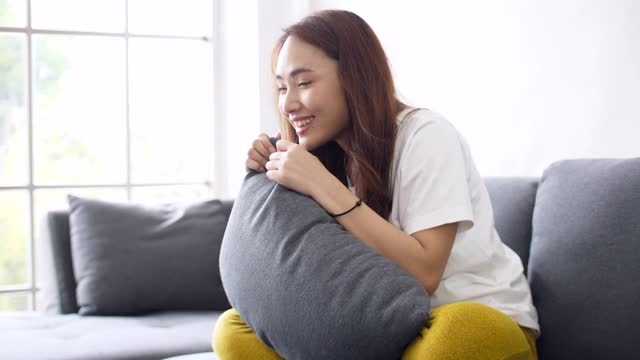 情绪化的年轻女子在沙发上看电视视频素材