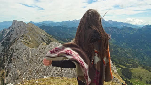 慢动作年轻的徒步旅行者拿着斗篷在山顶视频素材