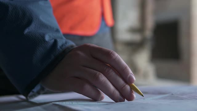 一位年轻的男建筑建筑师正在检查建筑的施工情况。工程师在高层建筑工地检查图纸。视频素材