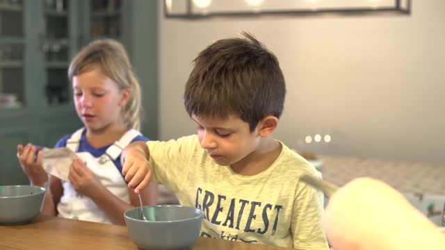 早上:孩子吃完早餐，妈妈在上学前给他戴上防护面具。视频素材