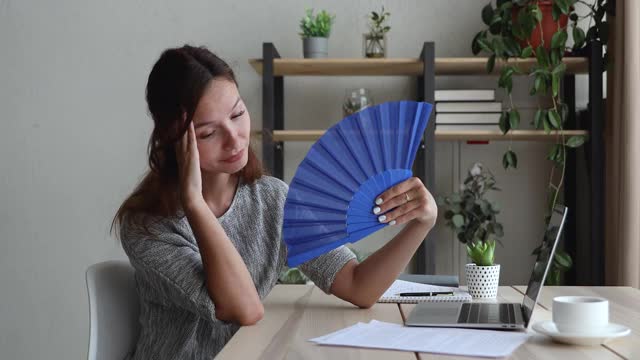 不快乐的红头发年轻女子用纸扇。视频素材