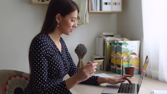 微笑的年轻女子用信用卡进行在线支付。视频素材