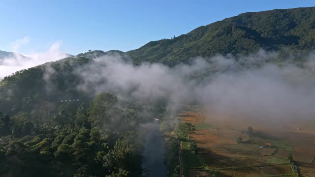 鸟瞰图村庄和田野透过云层，多莉拍摄视频素材