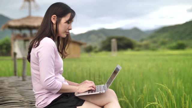 亚洲女性在户外使用笔记本电脑视频素材